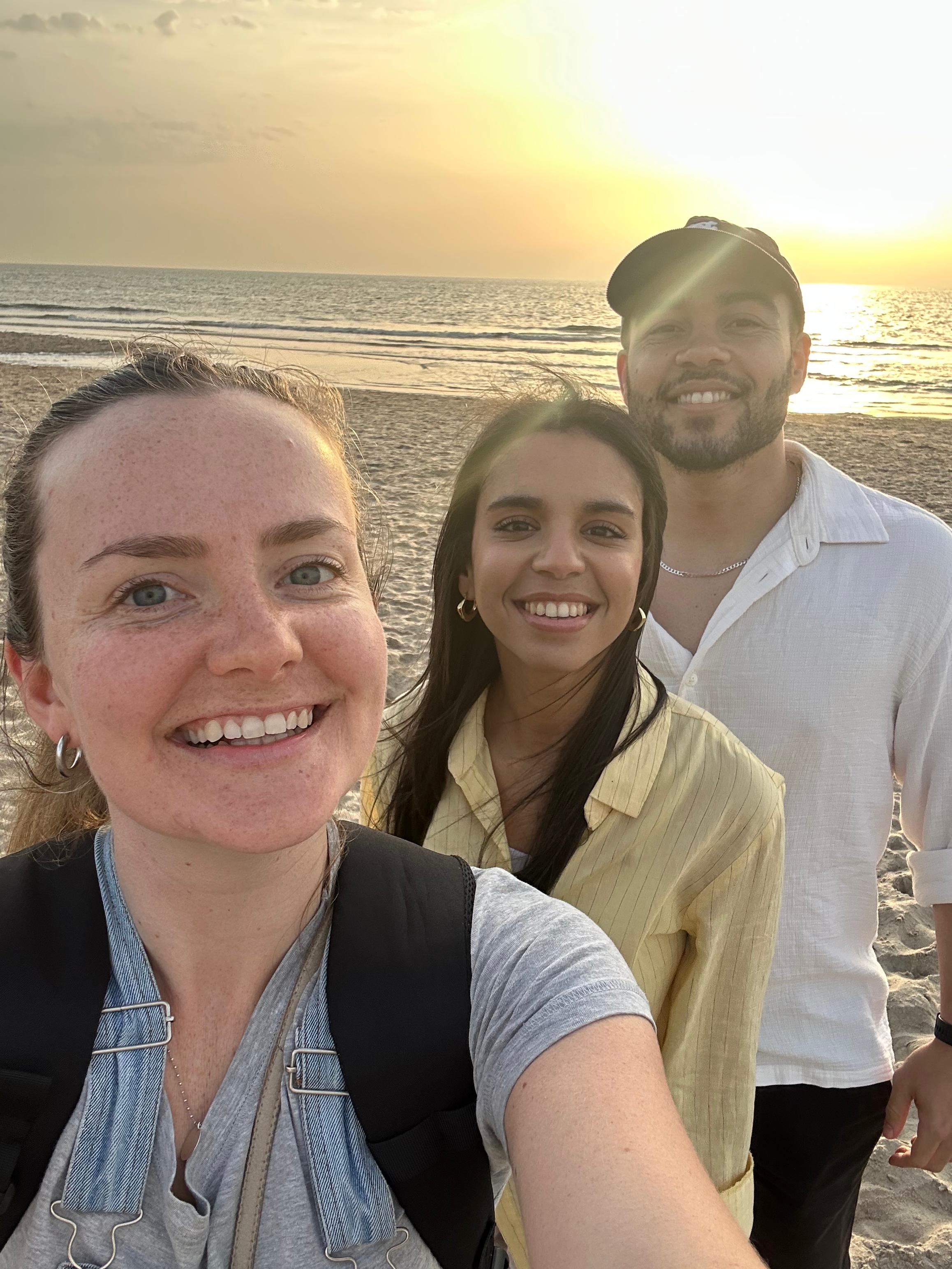 Selfie of me, the photographer with the couple on the beach with the ocean and sunset in the background.