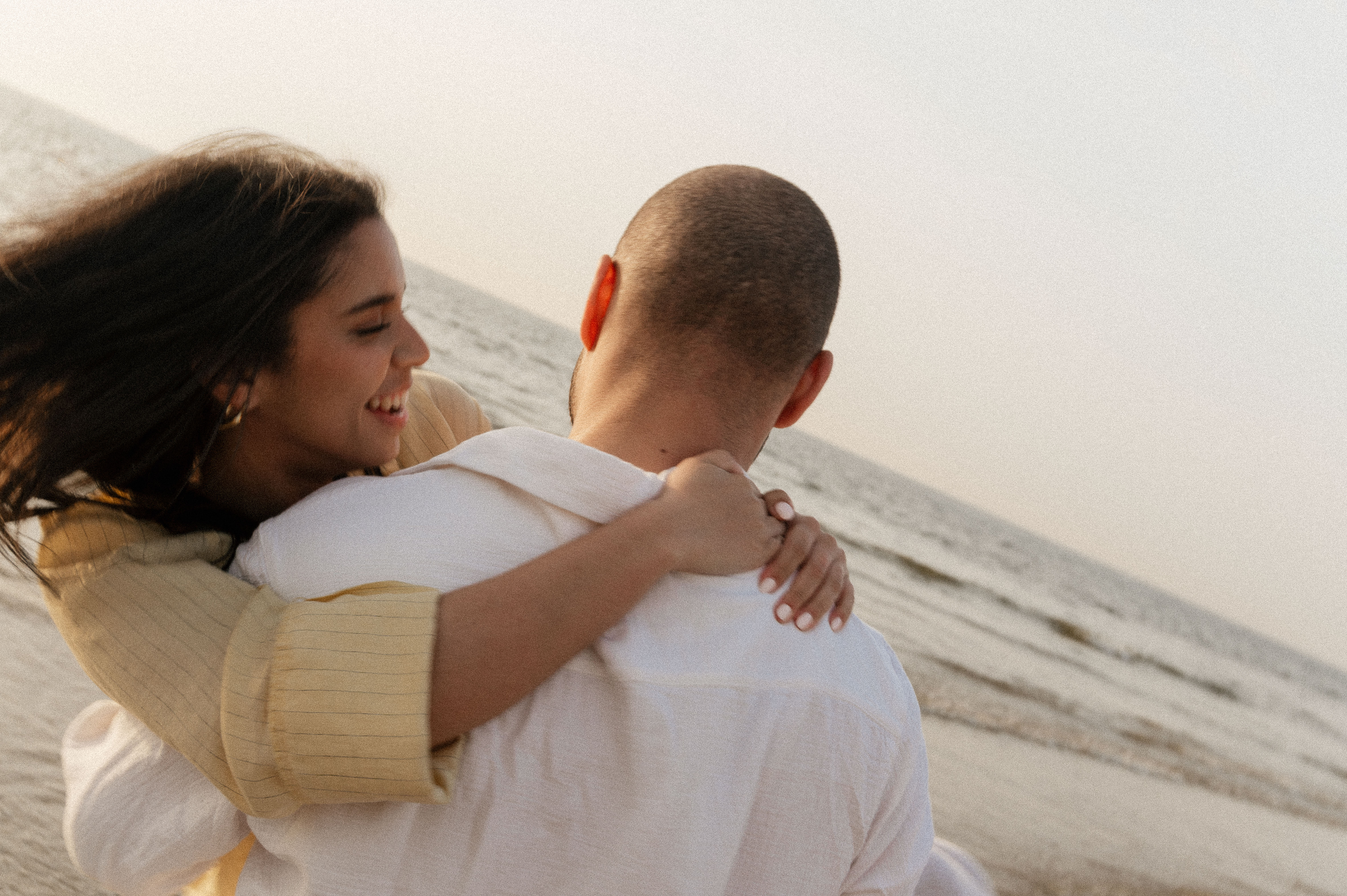 Close up shot of couple. Guy lifting girls in his arms and spinning around. Girl laughing.