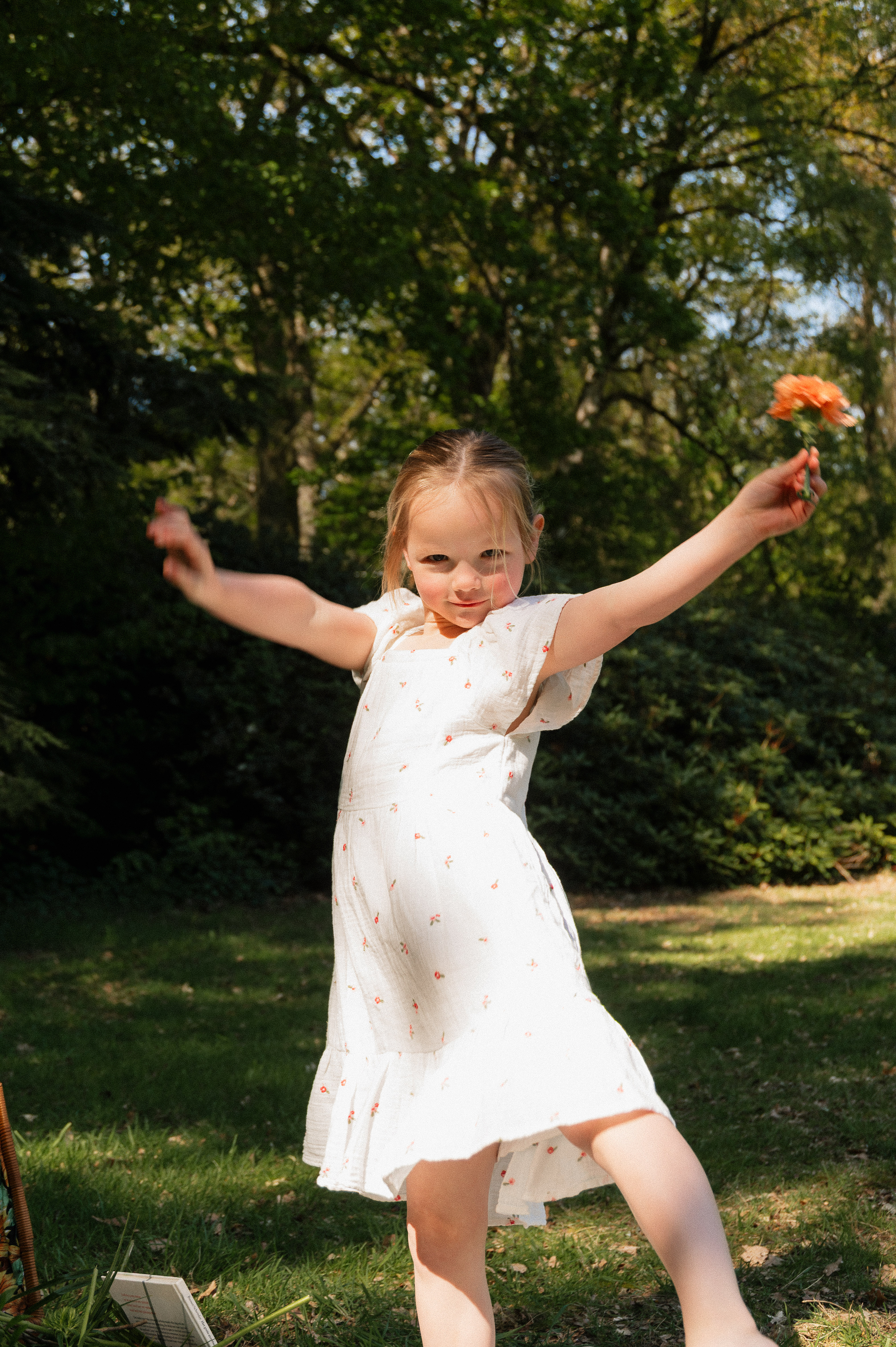 6 year old Girl dancing outside looking into camera.