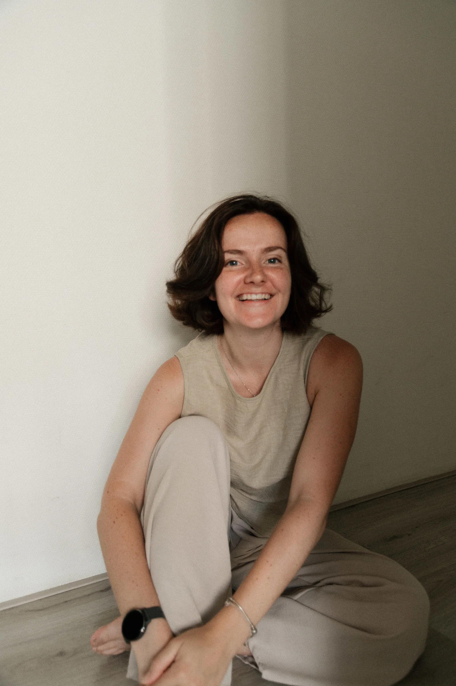 self-portrait of amber sitting on the floor in uneven lighting in her home.