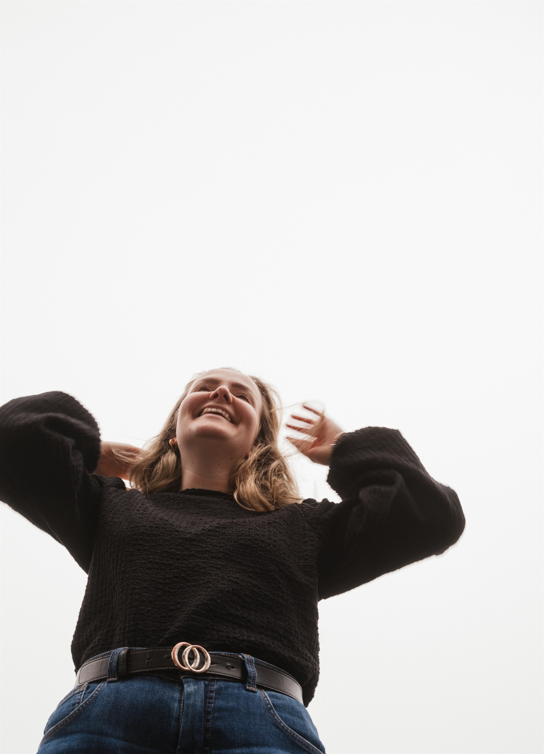 Amber laughing and looking up against a bright sky.