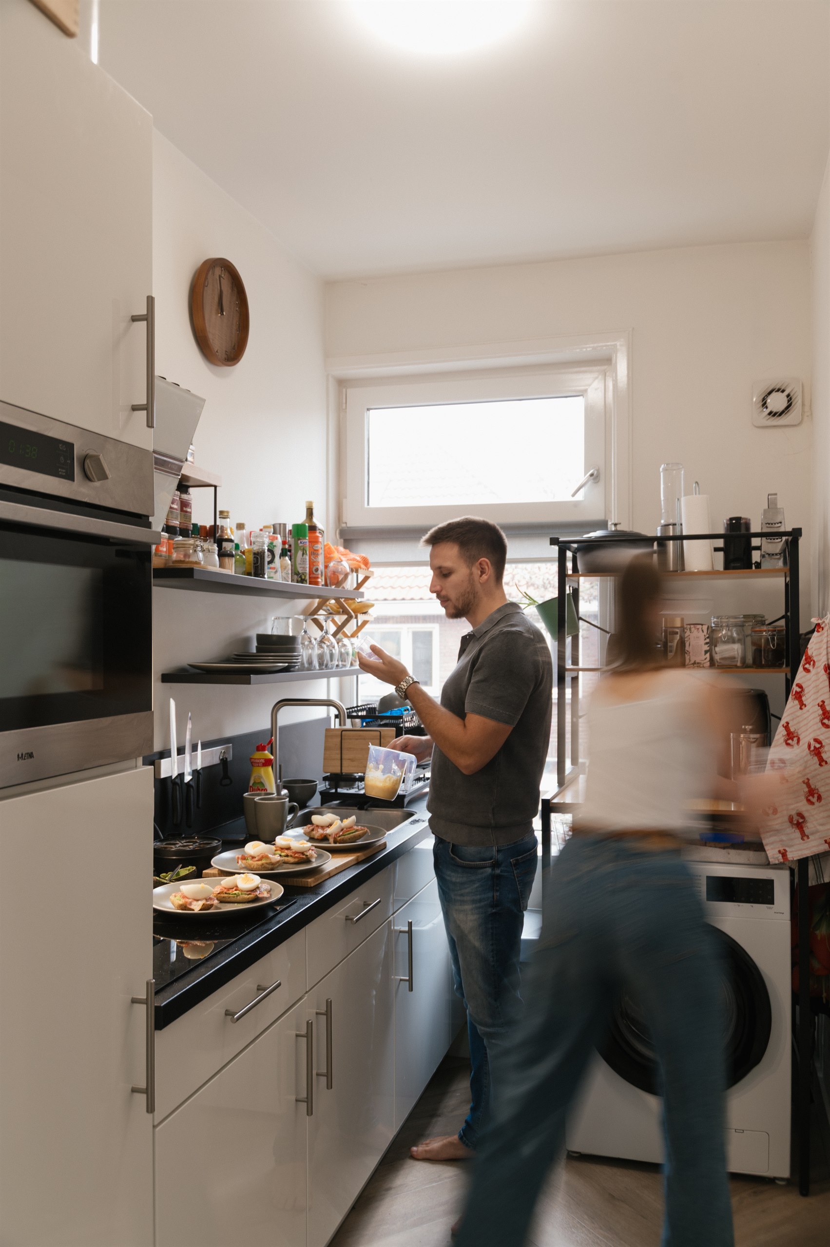 Couple moving together in the kitchen while one cooks.