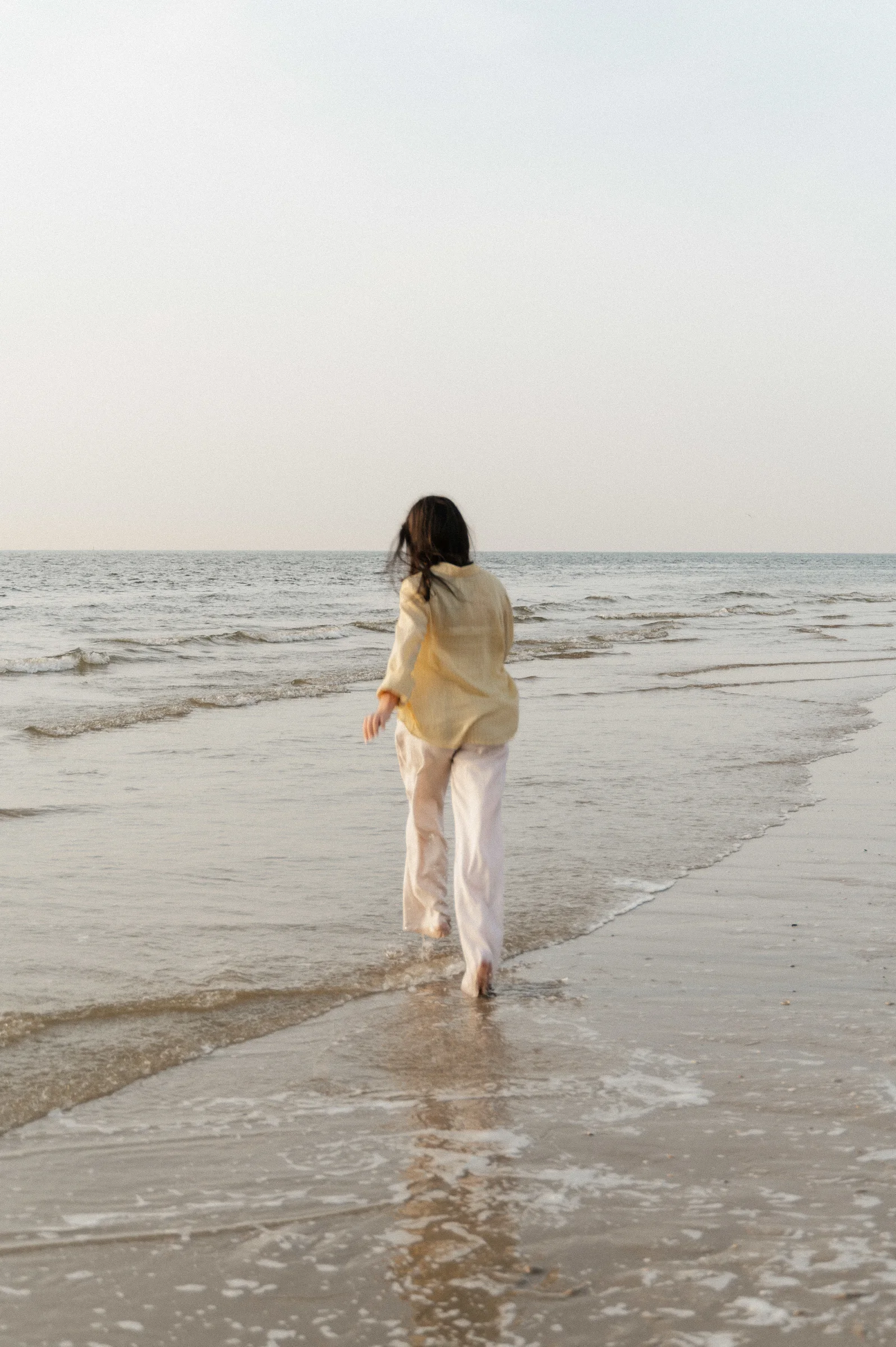 woman running into water at the beach