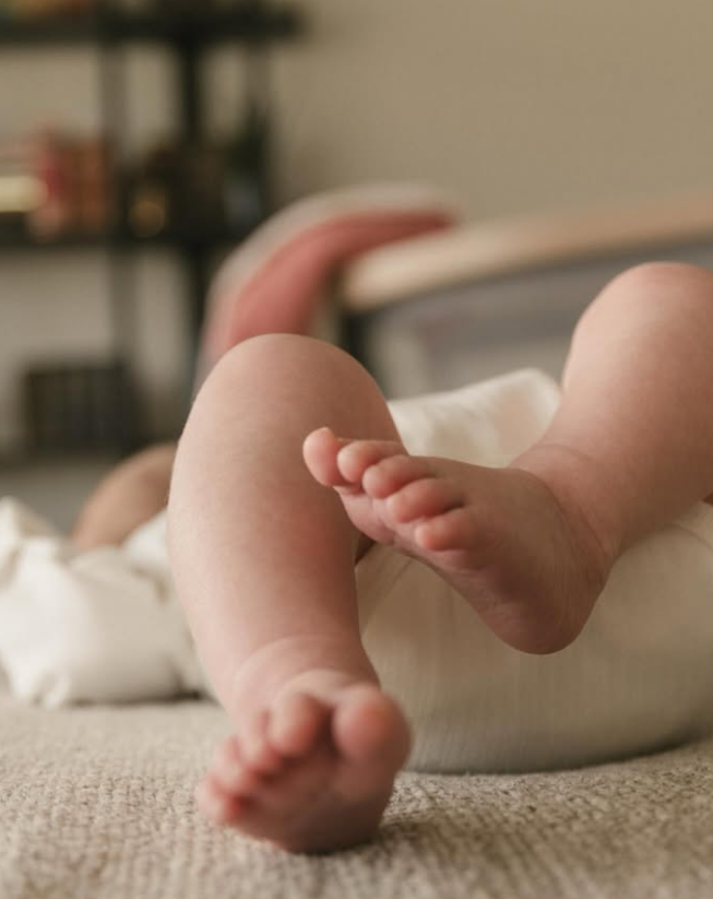 Close-up of a baby's feet resting on a blanket.