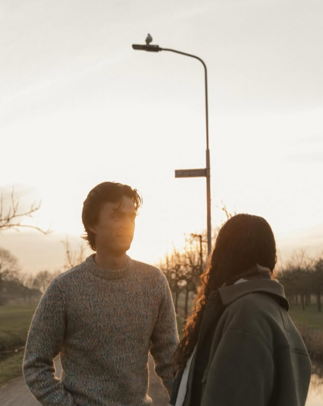 Couple standing together on a quiet residential street at sunset.