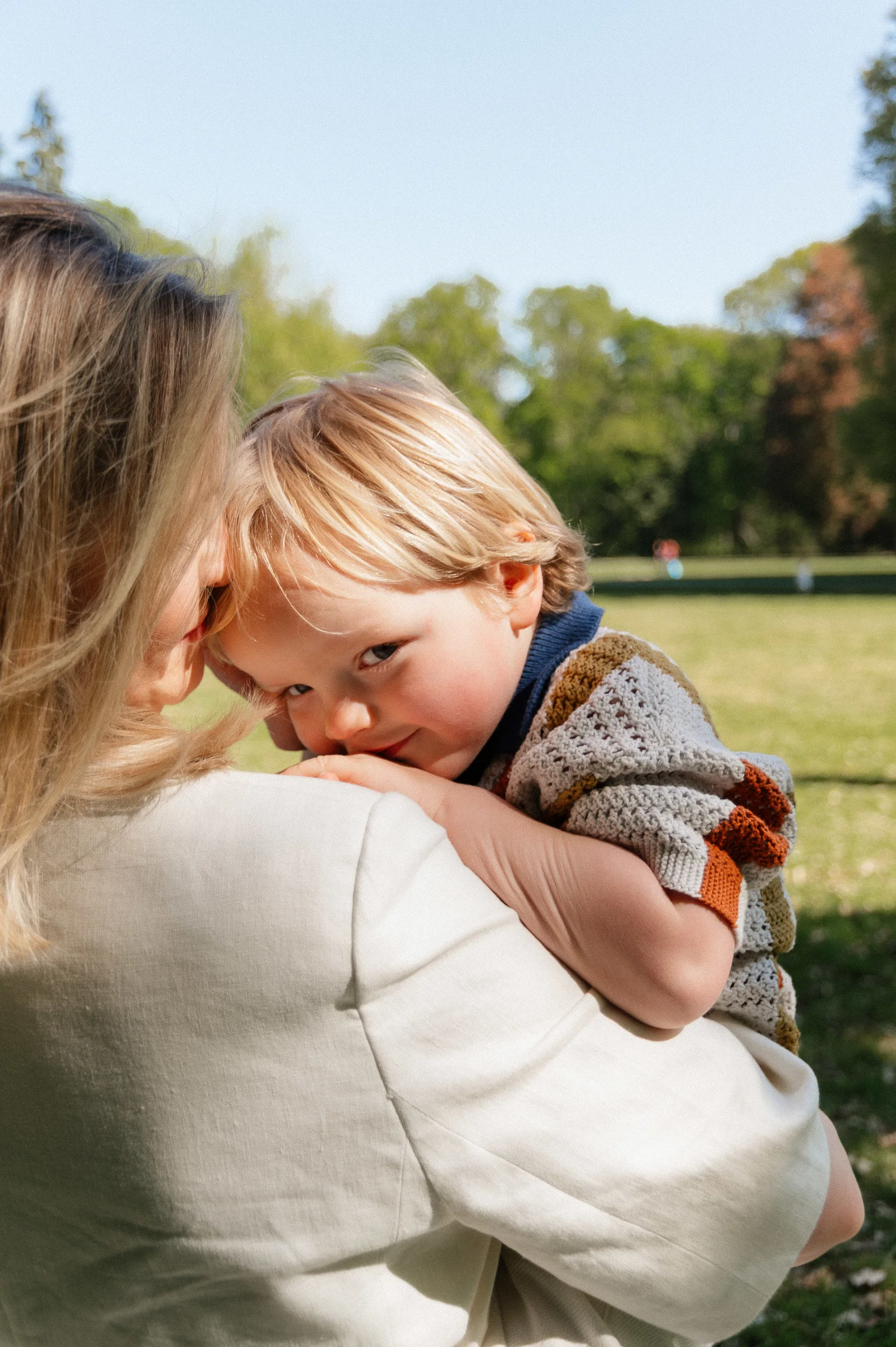 Mom holding son with son looking over mom's shoulder
