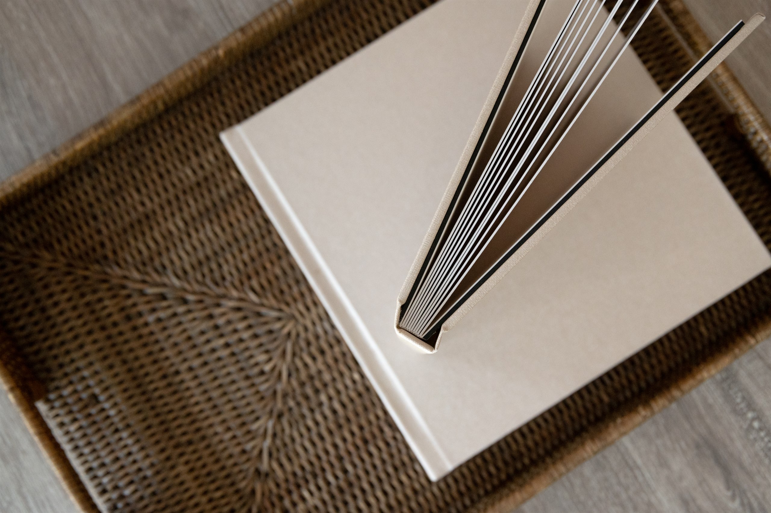 Heirloom photo album standing open on a woven tray.