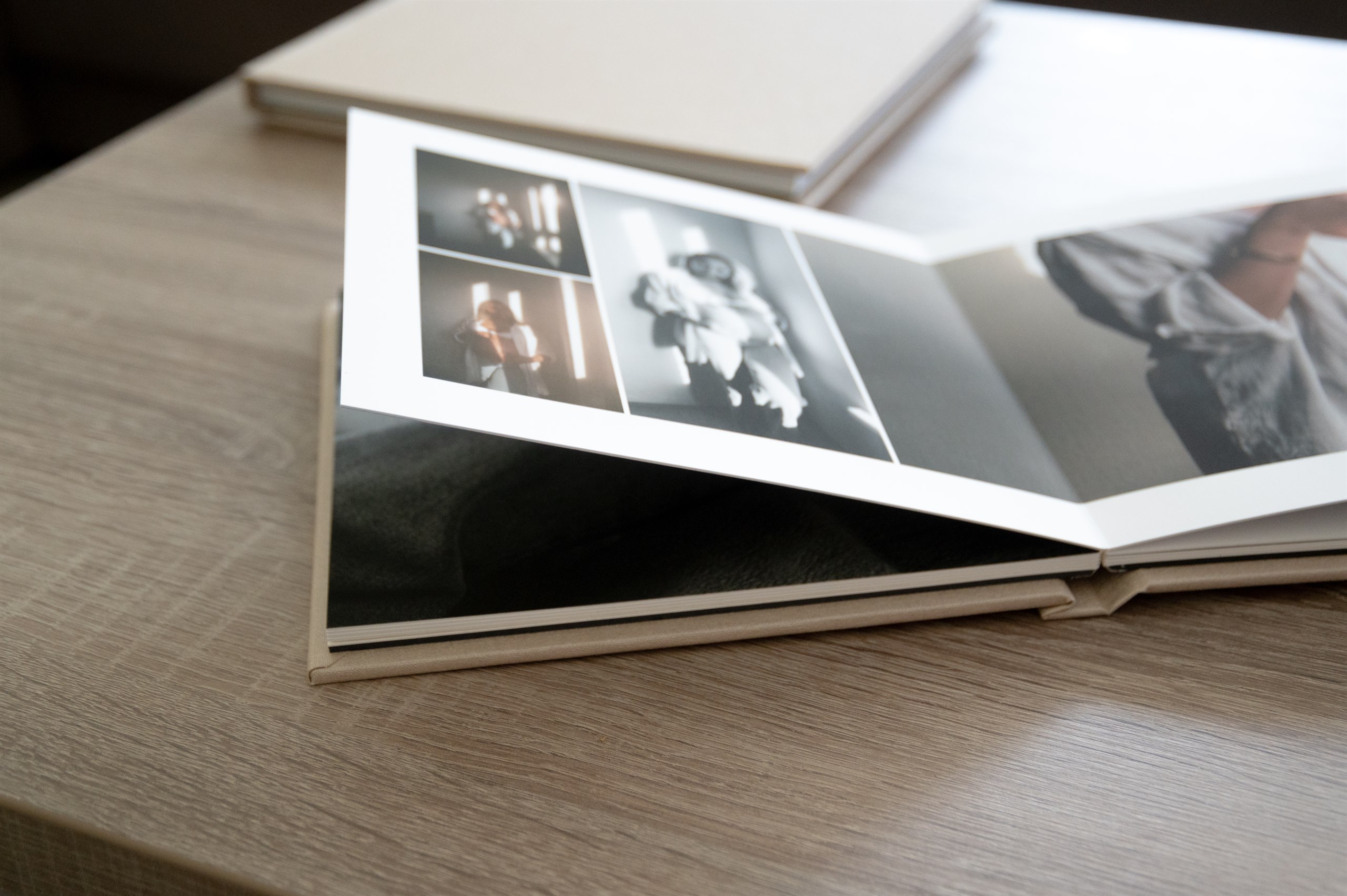 Open fine-art photo album displaying printed portrait photographs.