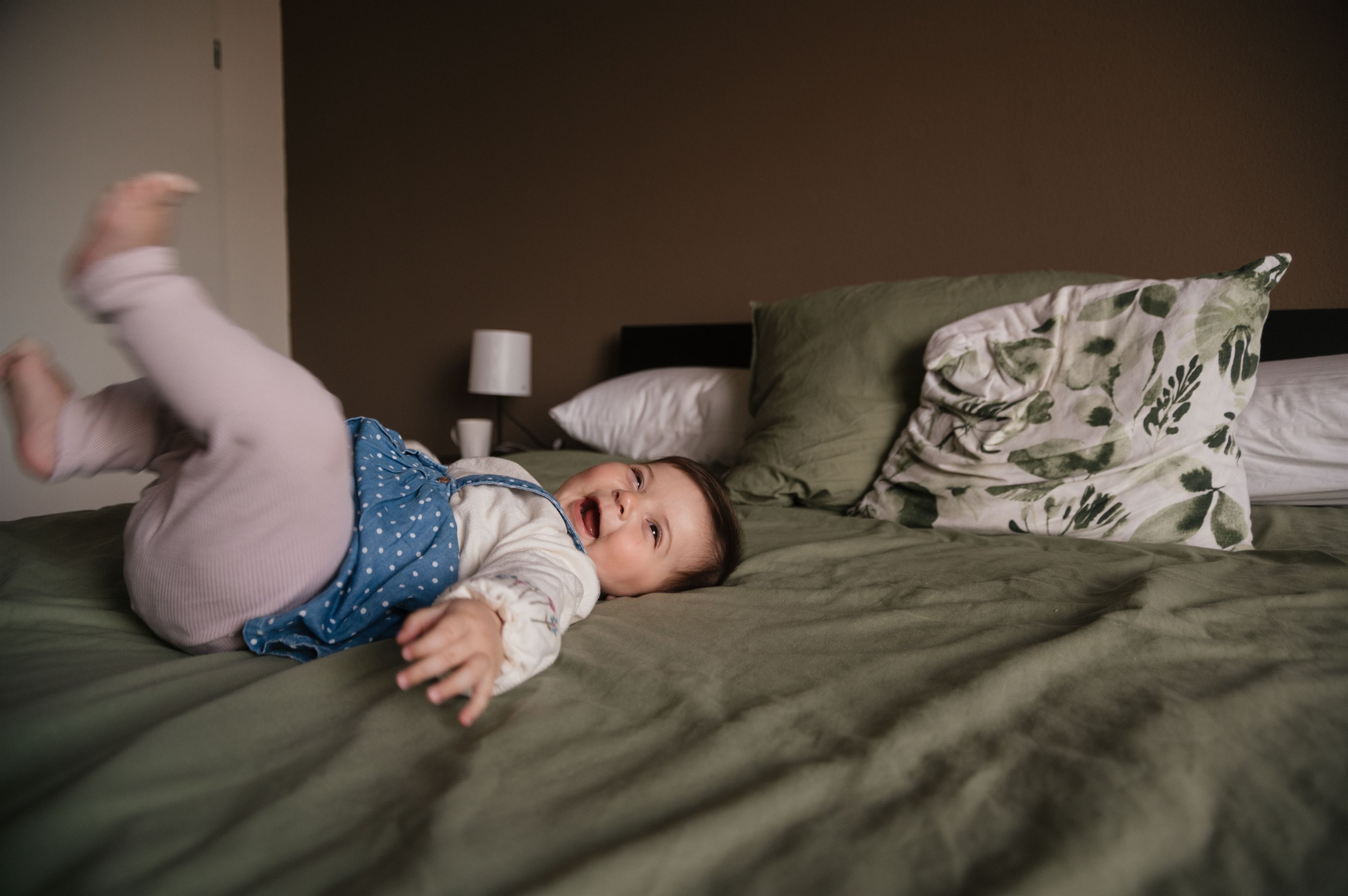 Baby rolling across a bed.