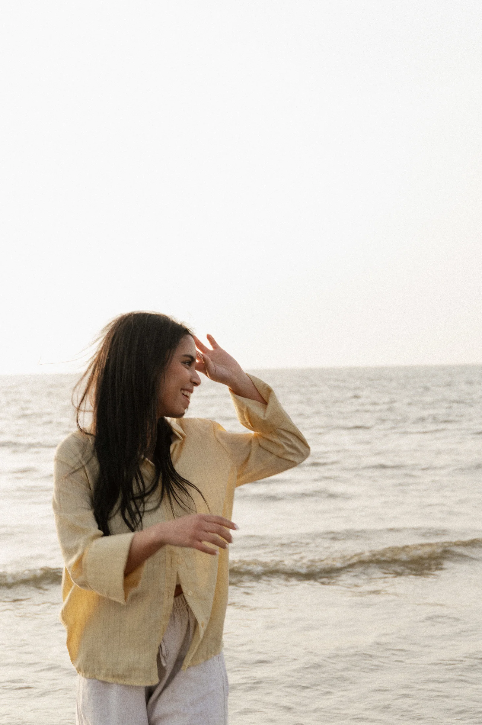 woman at beach putting hair behind ear